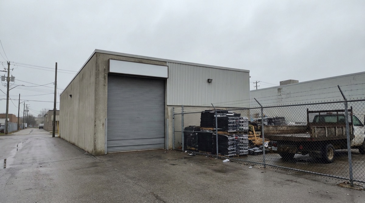 Roofing company shop and materials yard with a sign visible from the street